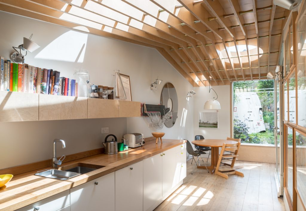 Light-filled kitchen extension with timber slatted ceiling, bespoke oak worktops, and full-height glazing – Hackney home renovation