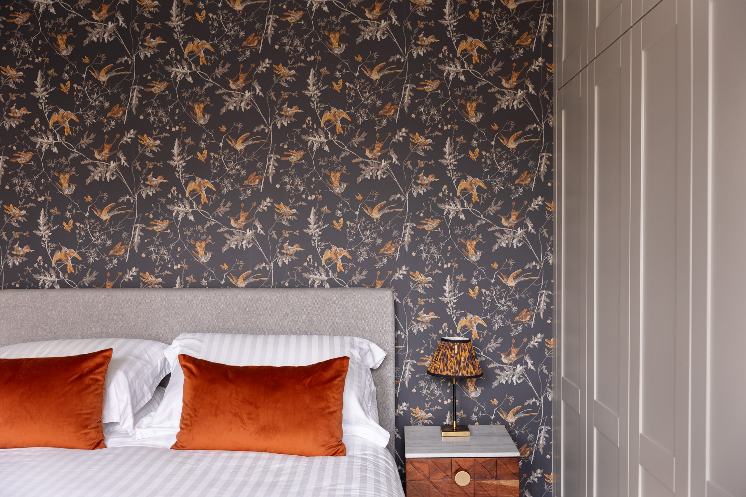Bedroom interior with bespoke joinery, feature wallpaper, and soft, layered lighting