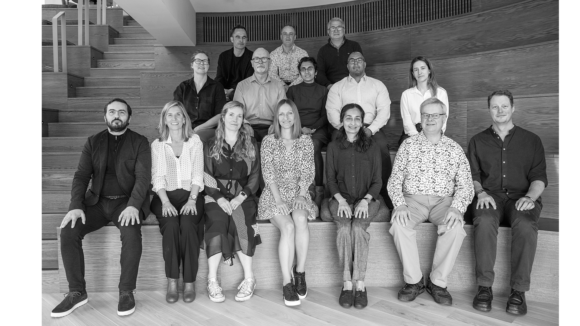 Architect Your Home team photo – a group of architects specialising in residential work and support team members in black and white on stepped seating