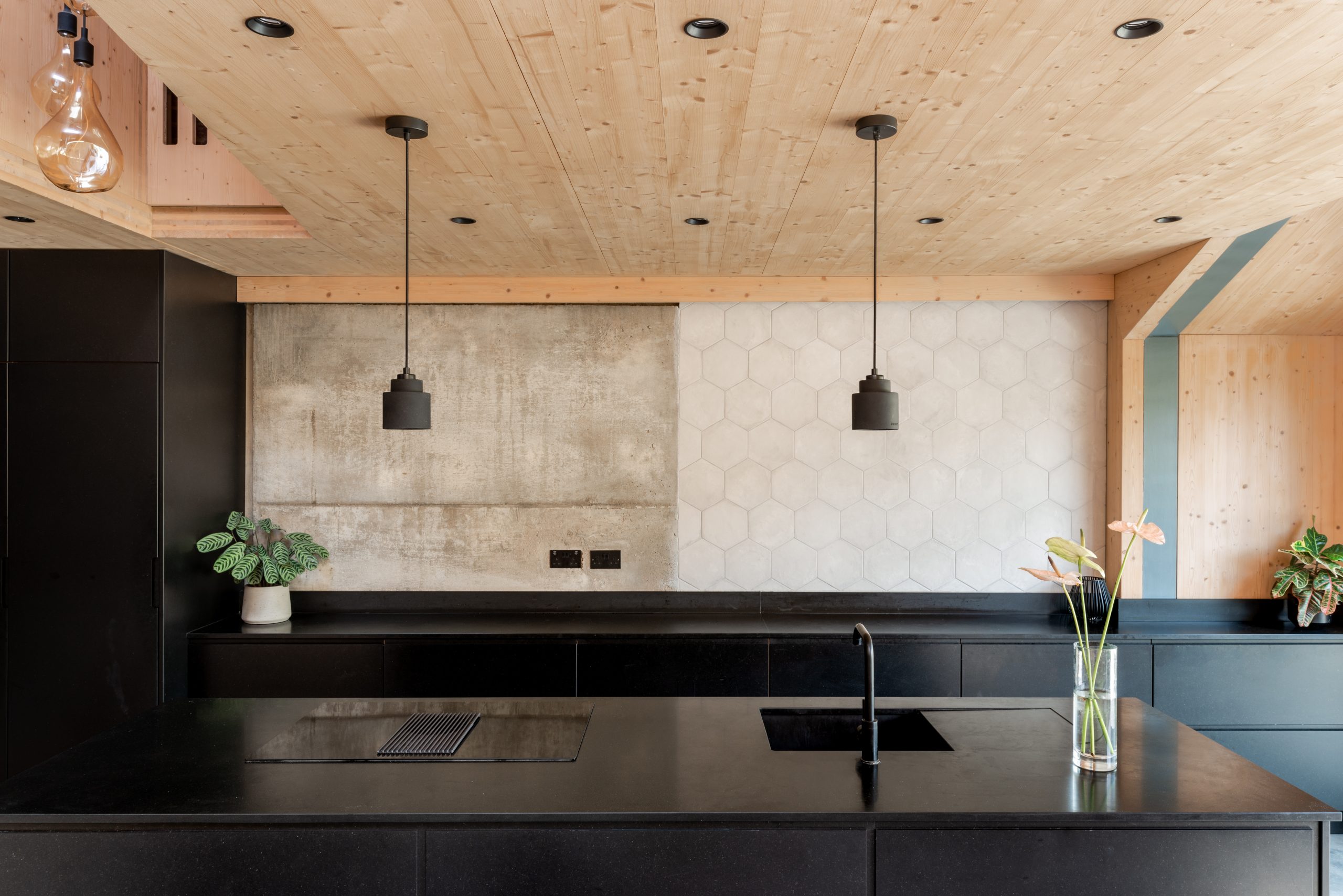 Contemporary kitchen with timber ceiling, black cabinetry, and feature concrete and hex tile walls